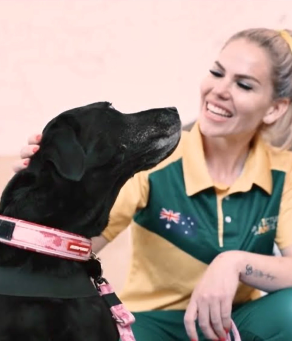 Handler in Australian uniform for Invictus games with her Integra Service Dog