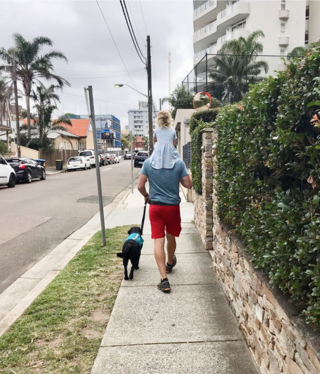 Handler, daughter and his Integra Service Dog walking down road